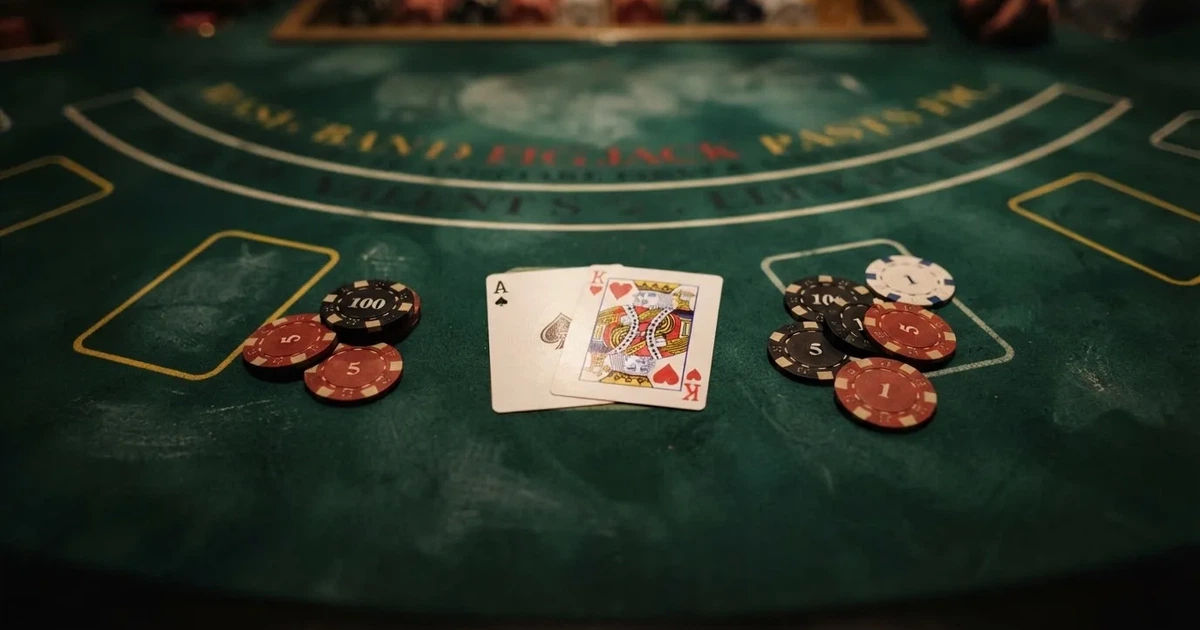A close-up of a blackjack table felt with cards and chips laid out, no dealer or players visible.
